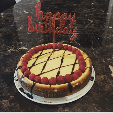Vanilla cheesecake with raspberries and chocolate sauce.